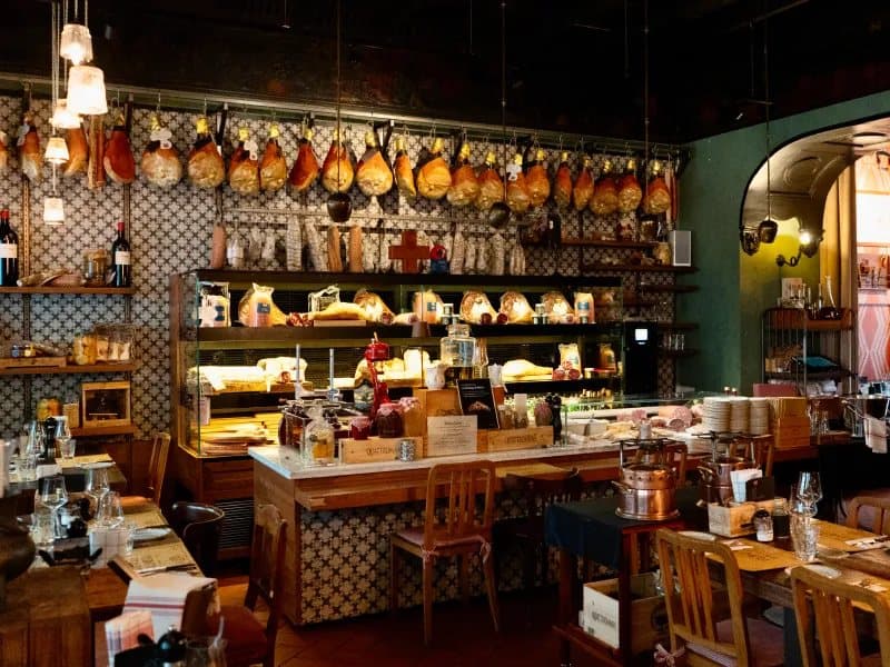 A delicatessen with hams hanging above the counter, shot for Genusstour