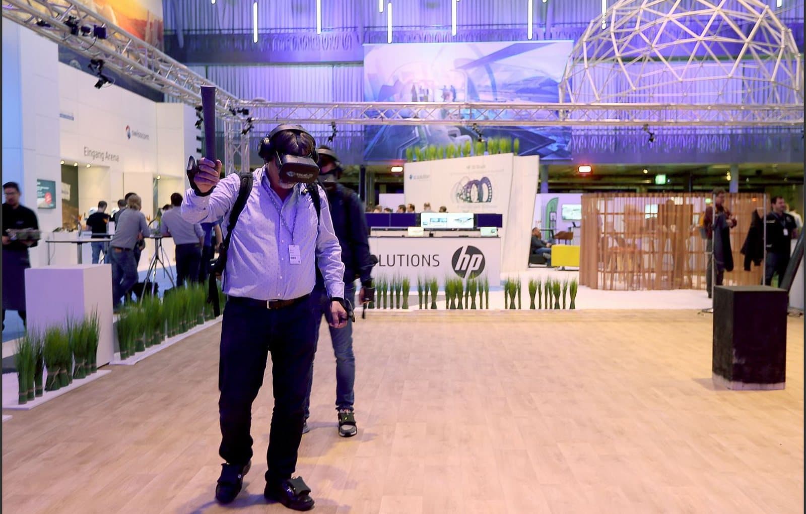A visitor walking through a trade fair hall wearing a trueVR headset